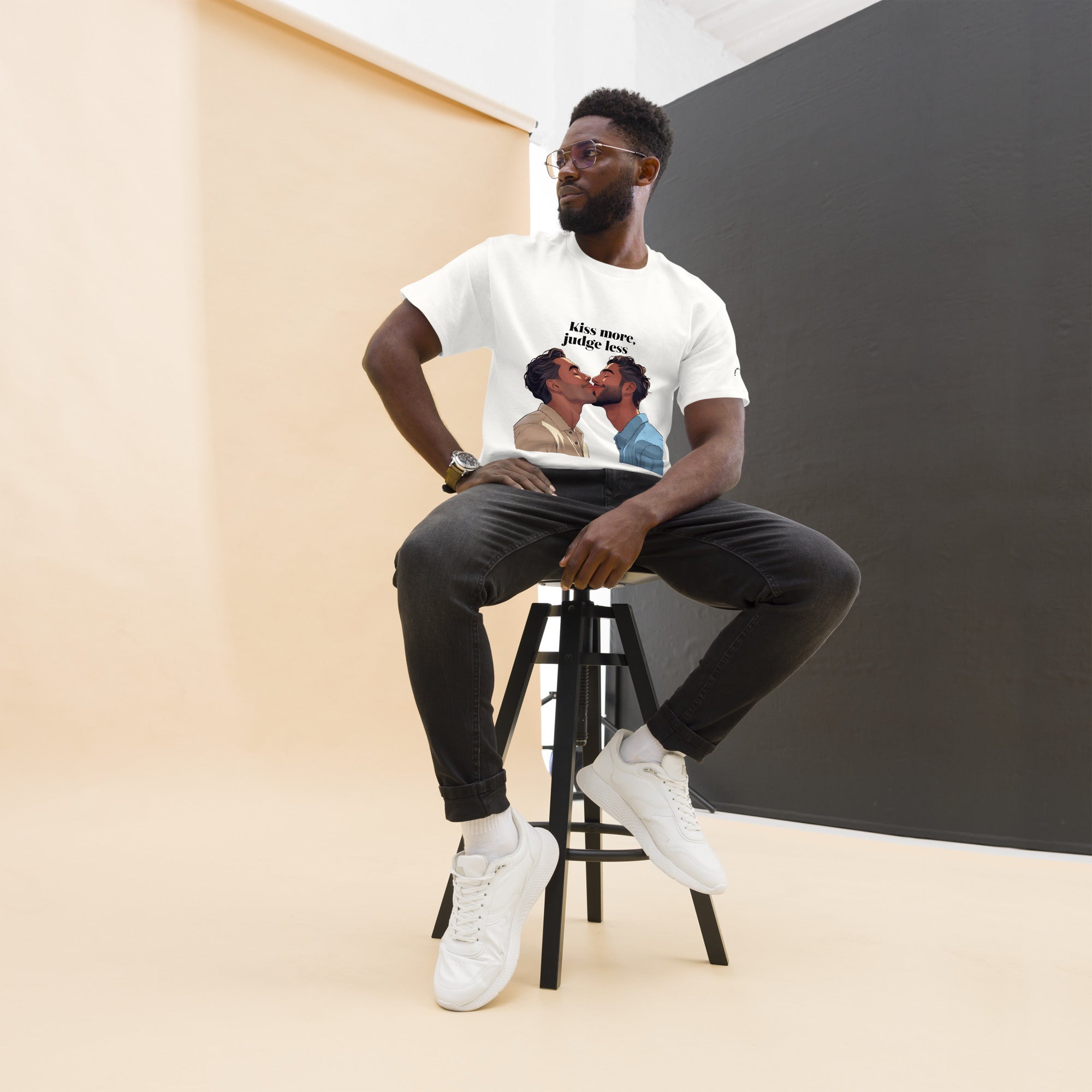 Person sitting on a stool wearing a white t-shirt with a graphic design.