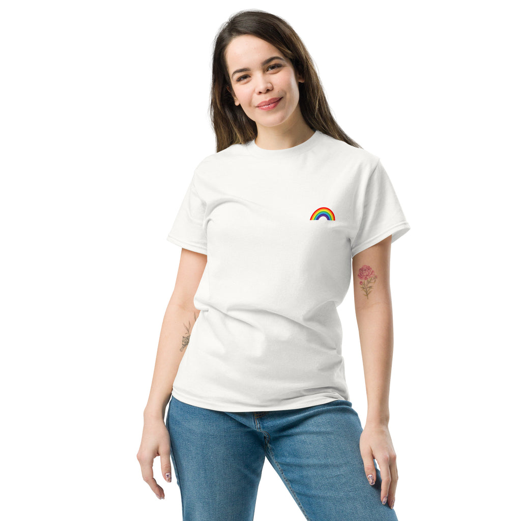 Woman wearing a white t-shirt with a rainbow design on a plain background