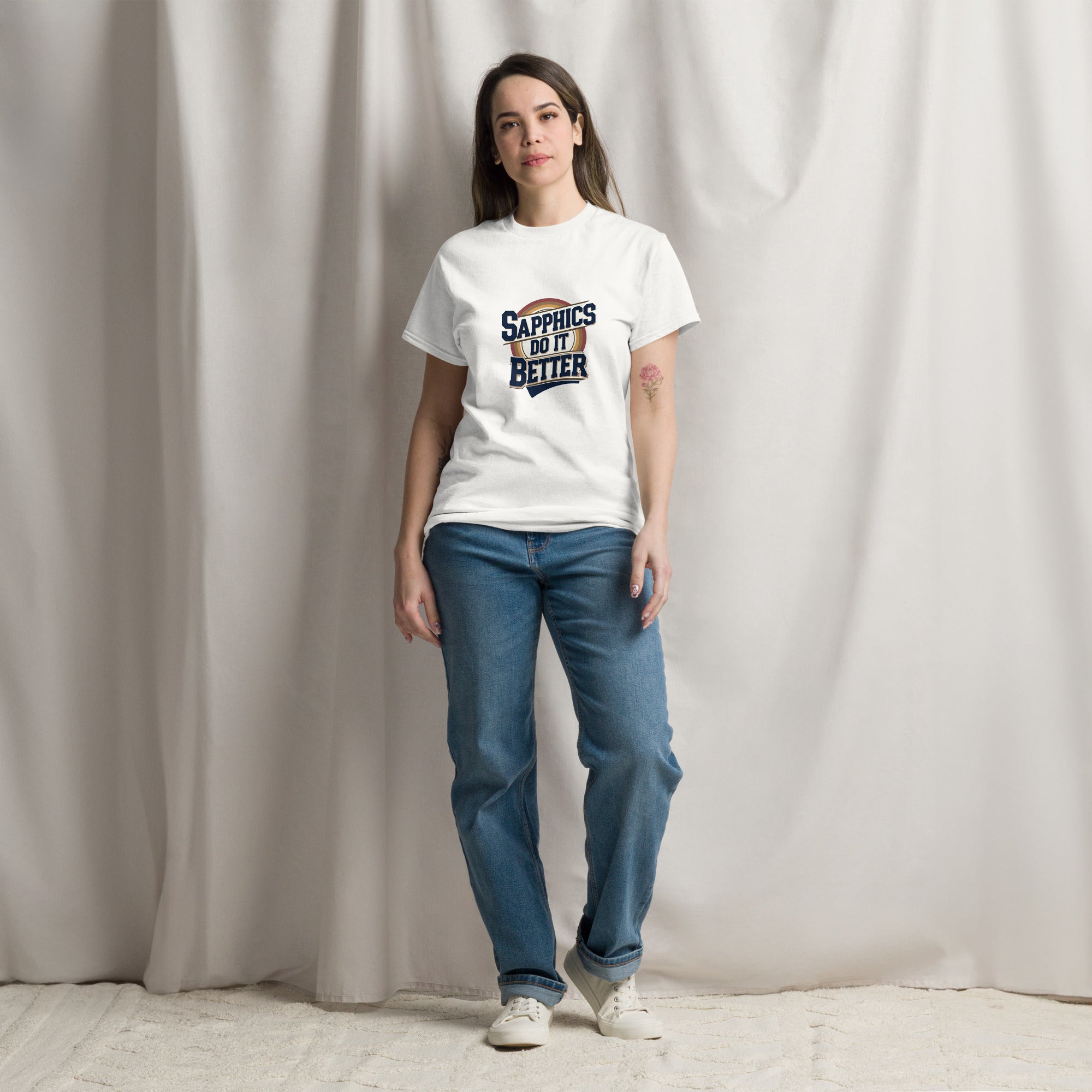 Person wearing a white t-shirt with text and blue jeans against a plain background