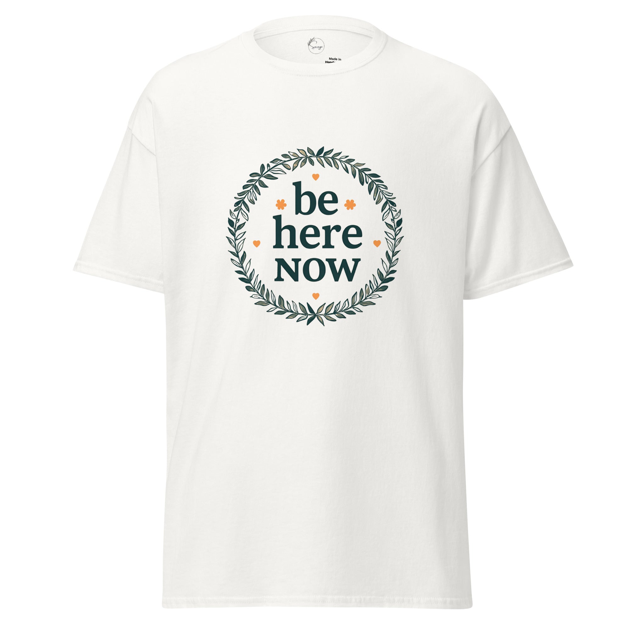 White t-shirt with 'be here now' text and wreath design on a white background