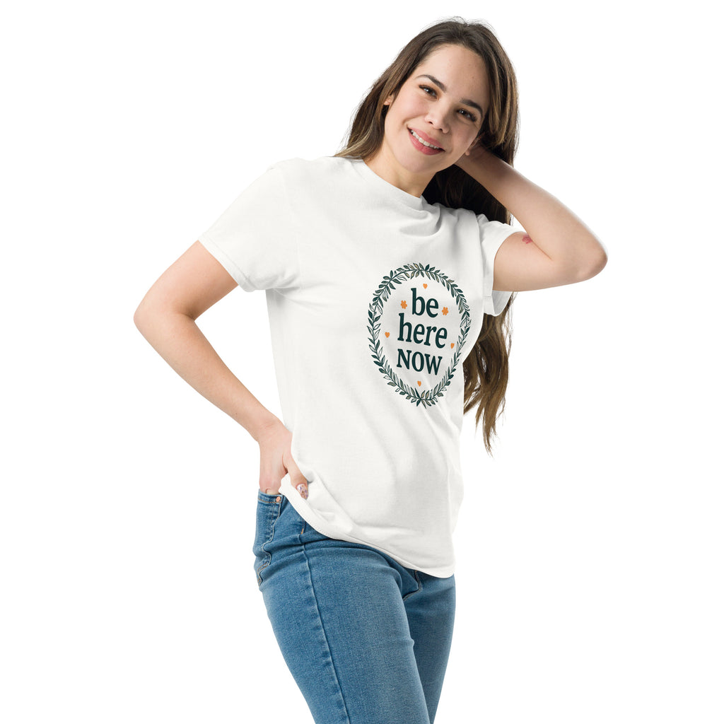 Woman wearing a white t-shirt with 'be here NOW' text design on a white background