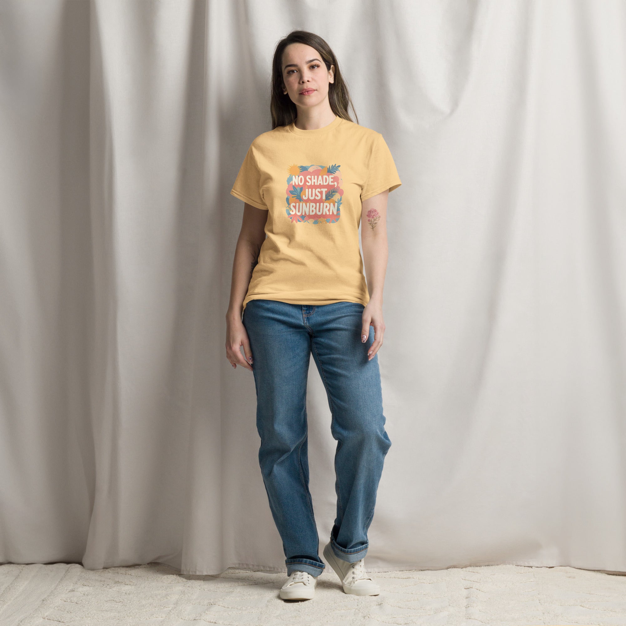 Model wearing No Shade, Just Sunburn slogan T-shirt by Savage Cotton in sunshine yellow, styled with sunglasses and a Pride flag