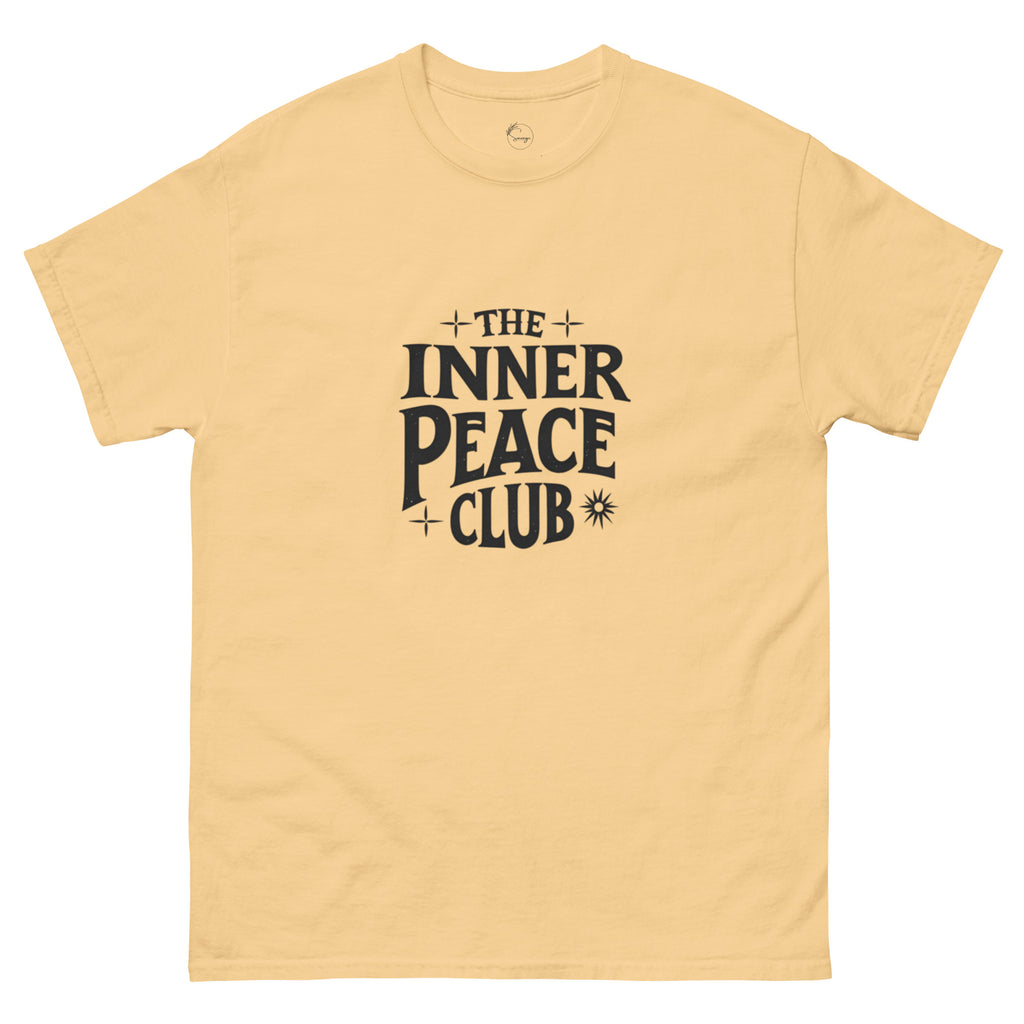Flat lay of a cream-colored “The Inner Peace Club” t-shirt with soft lettering, styled with pastel accessories and cozy neutral tones.