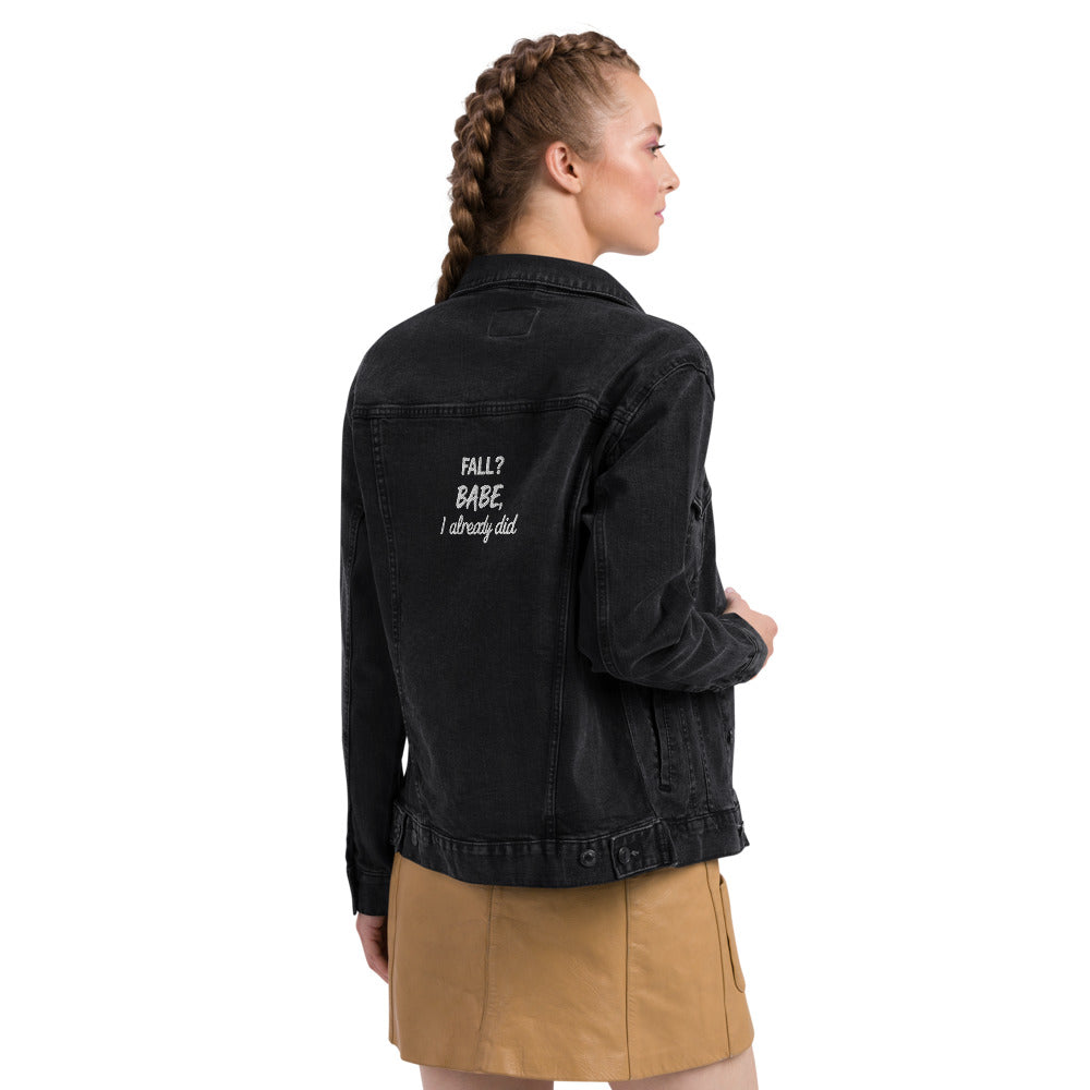 Person wearing a black jacket with text on the back, standing against a white background