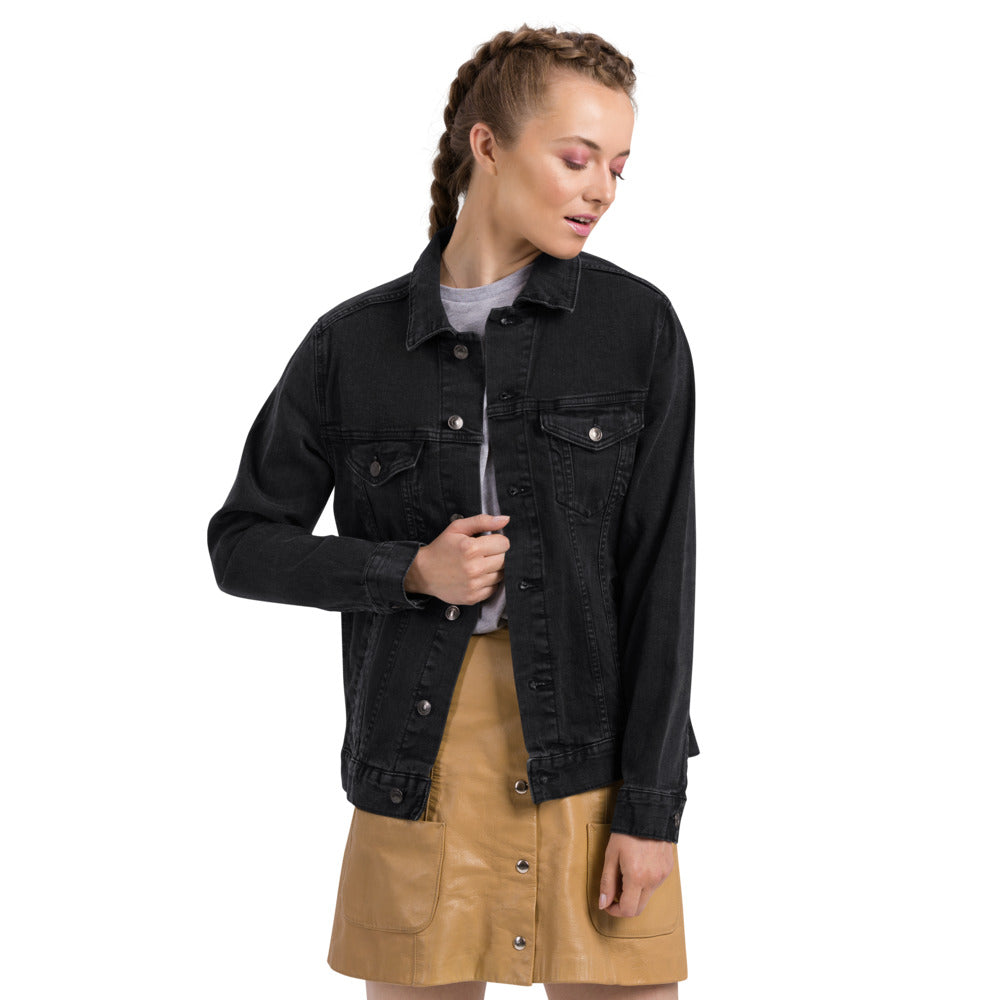 Person wearing a black denim jacket over a beige skirt on a white background