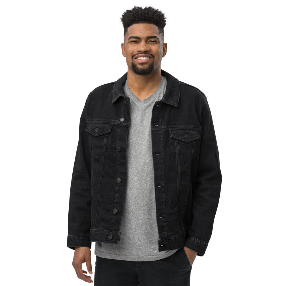 Man wearing a black denim jacket over a gray shirt on a white background