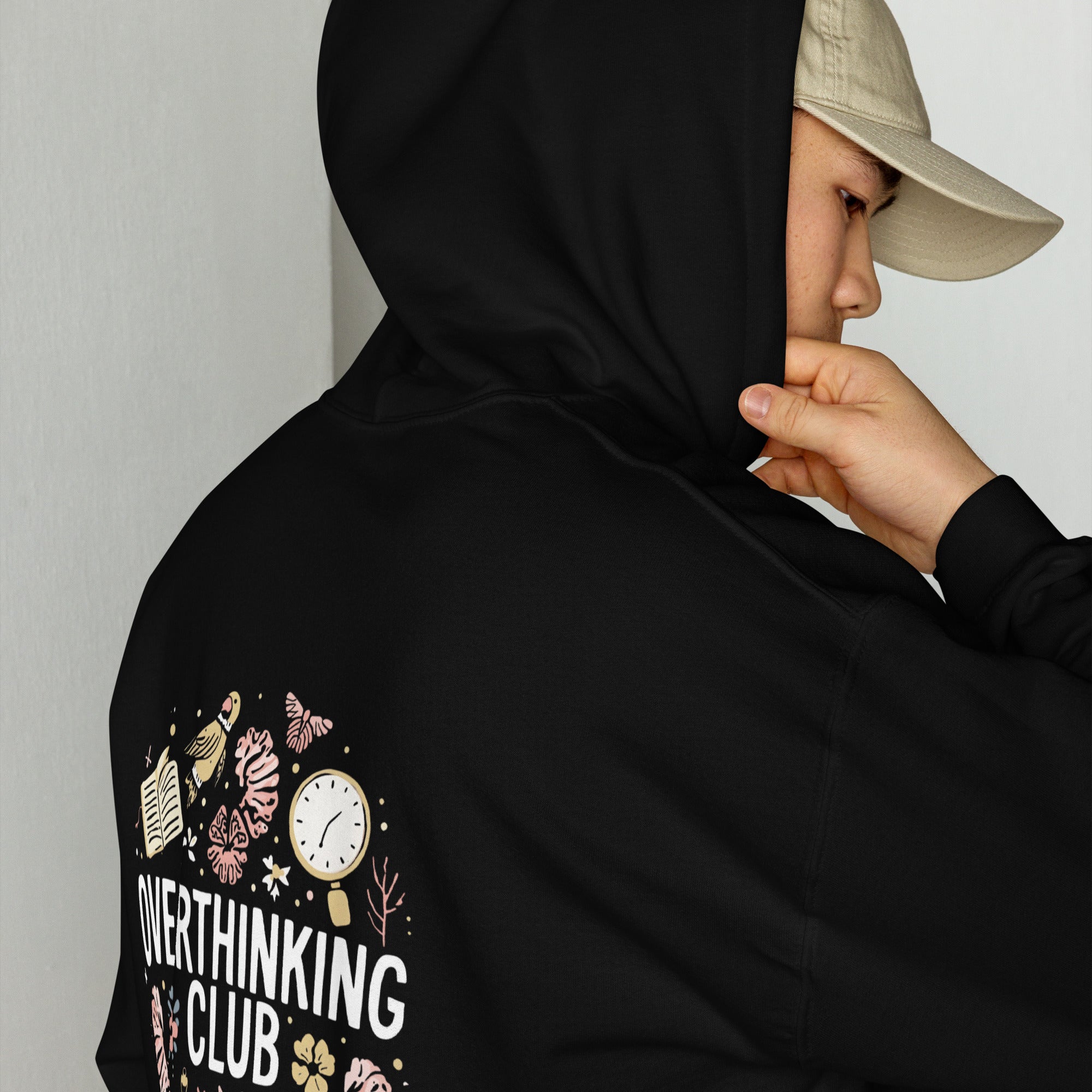 Person wearing a black hoodie with 'Overthinking Club' design on the sleeve, against a plain background.