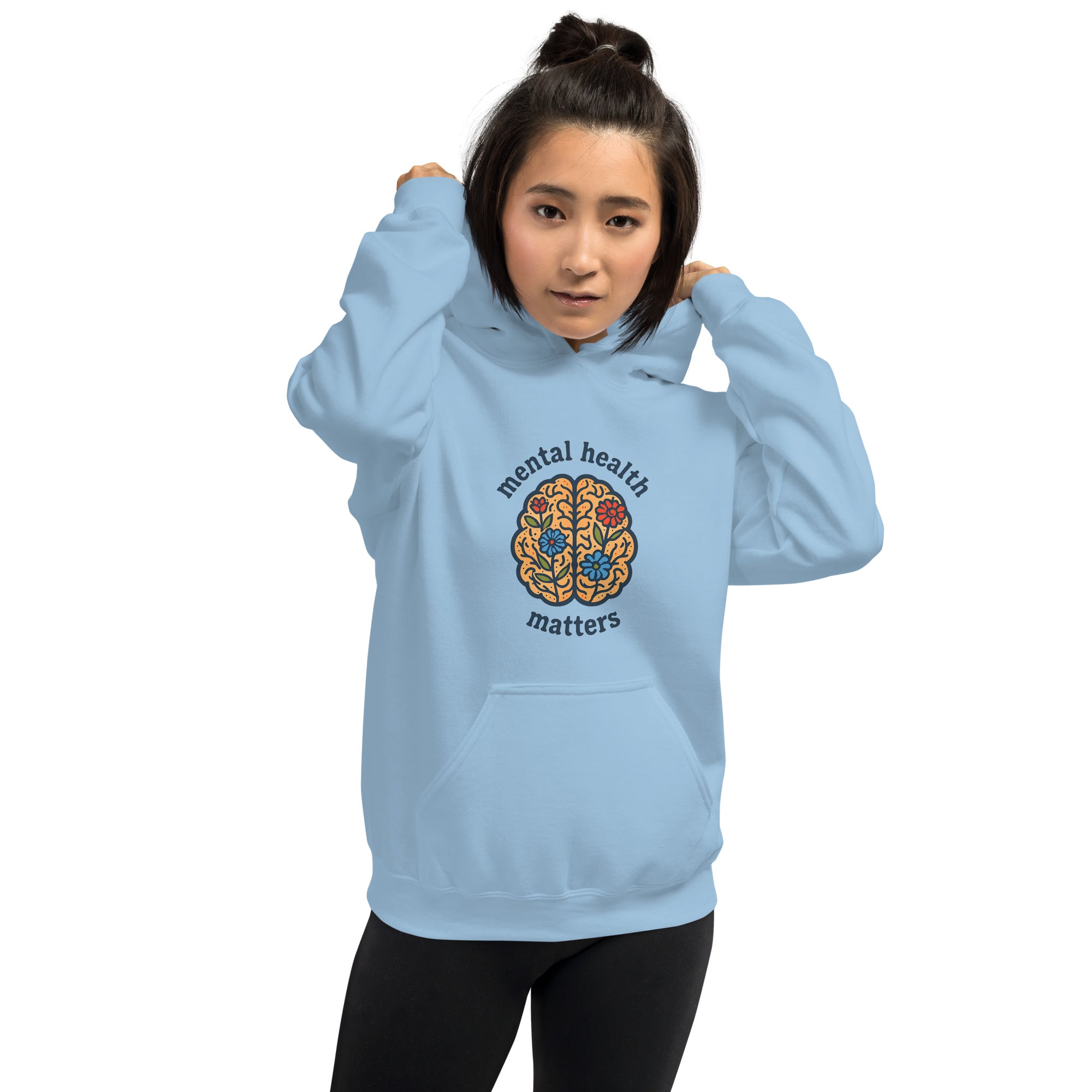 Person wearing a light blue hoodie with a colorful brain design and 'mental health matters' text on a white background