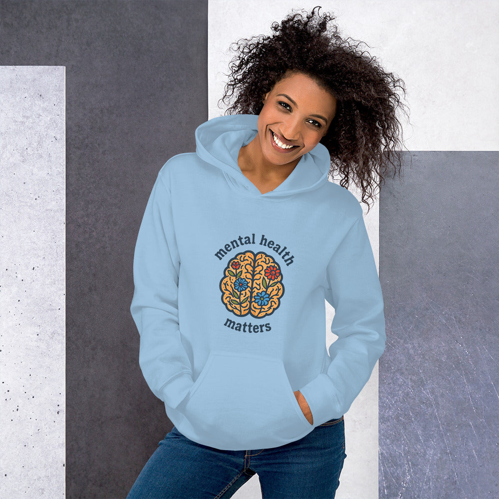 Person wearing a light blue hoodie with 'mental health matters' design on a gray and white background